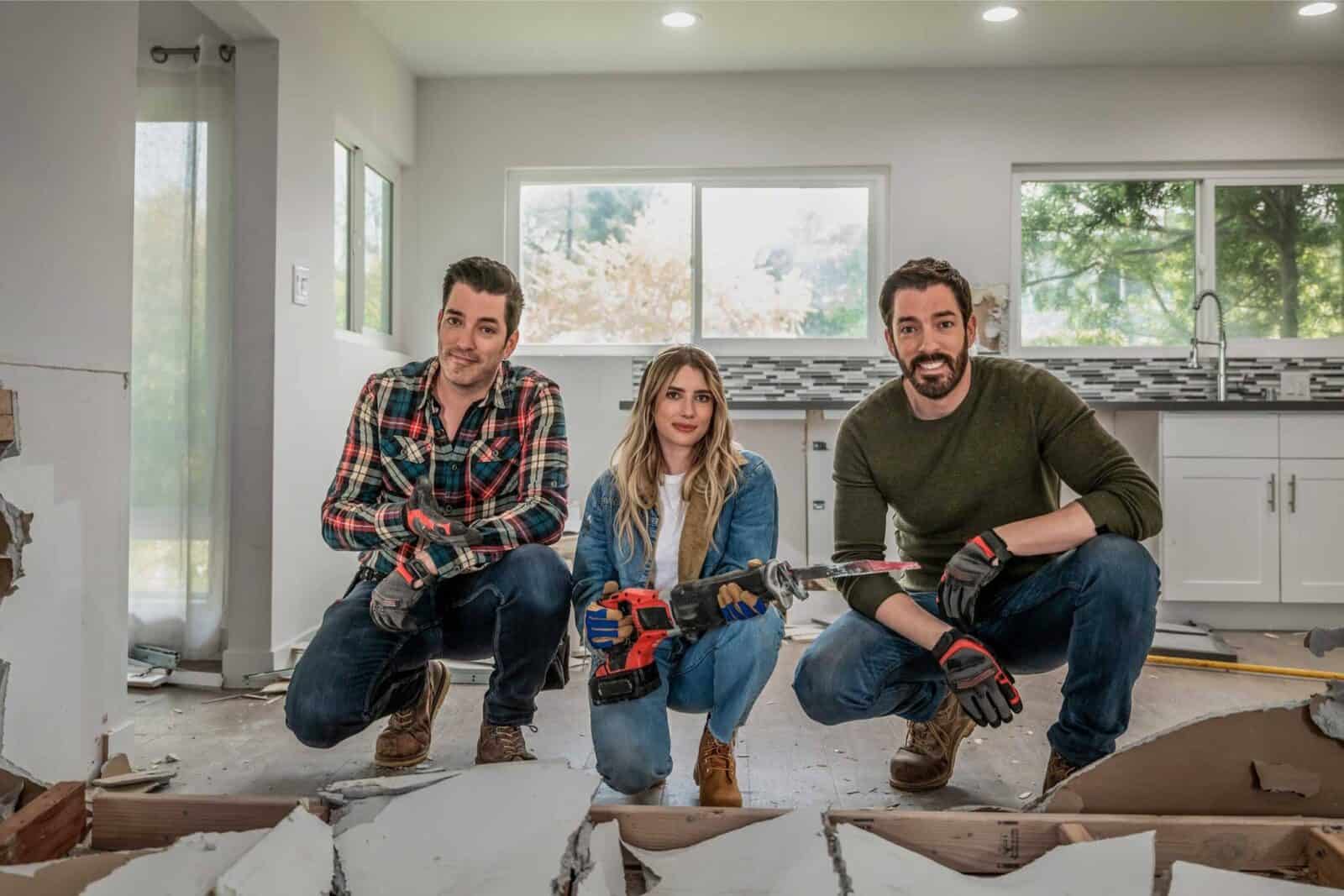 Scott brothers and a woman posing in a partially renovated room.