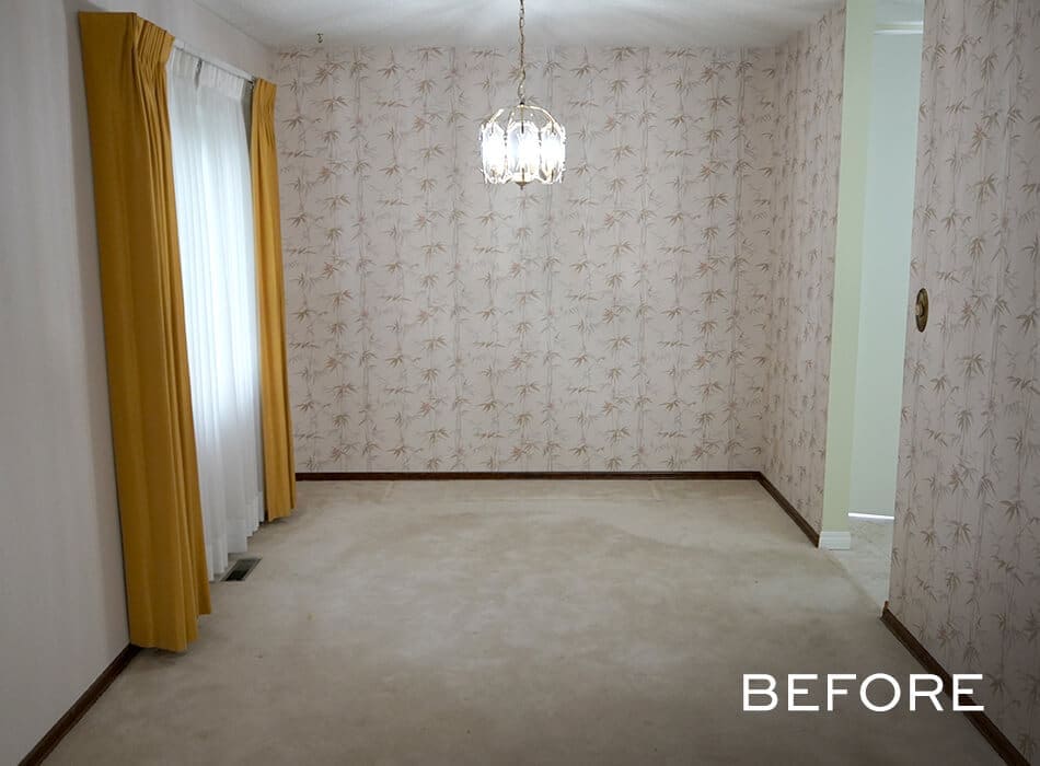 Empty room with floral wallpaper, yellow curtains, a hanging light fixture, and beige carpeting