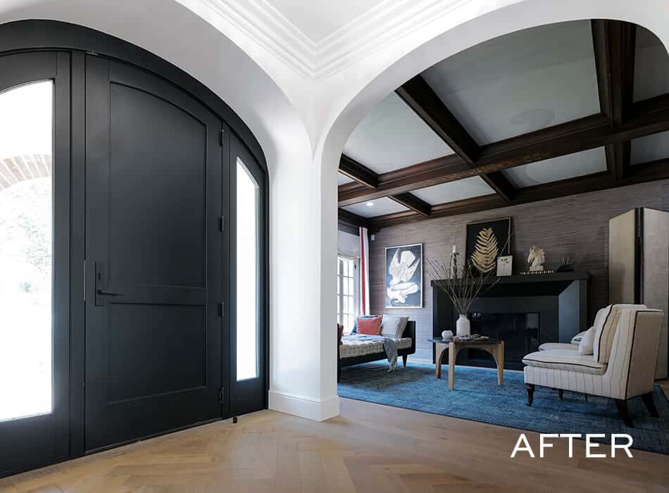 Entryway with black doors leading to a living room with blue rug and modern furniture