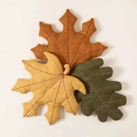Three leaf-shaped pillows in orange, yellow, and green