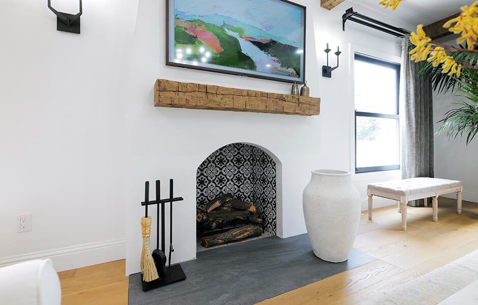 Living room with a white, curved brick fireplace, and a large painting hanging on the wall
