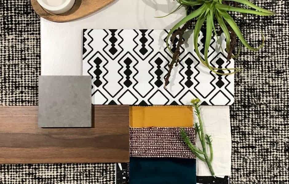 Flat lay of home decor materials including patterned tile, fabric swatches, and wood sample