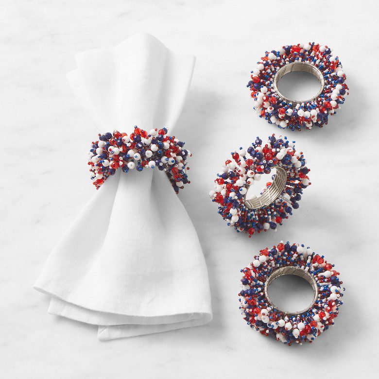 White cloth napkin with a beaded red, white, and blue napkin ring