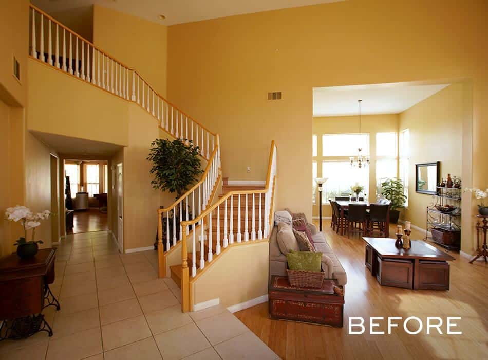 Spacious home interior with yellow walls, a staircase, and traditional furnishings