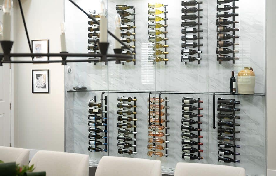 Dining room with a glass-enclosed wine cellar featuring multiple rows of wine bottles