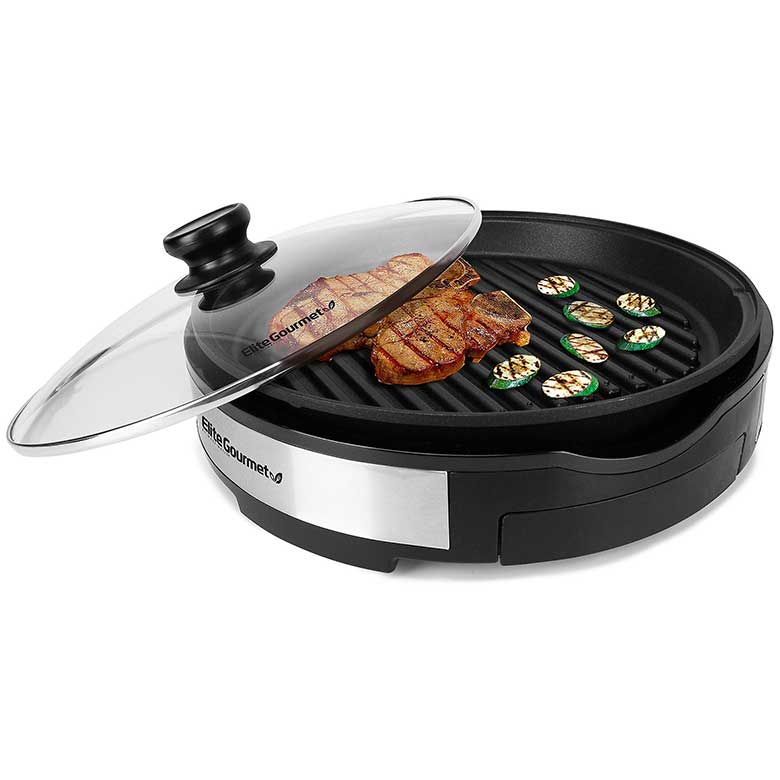Electric indoor grill with a glass lid, grilling steak and sliced zucchini