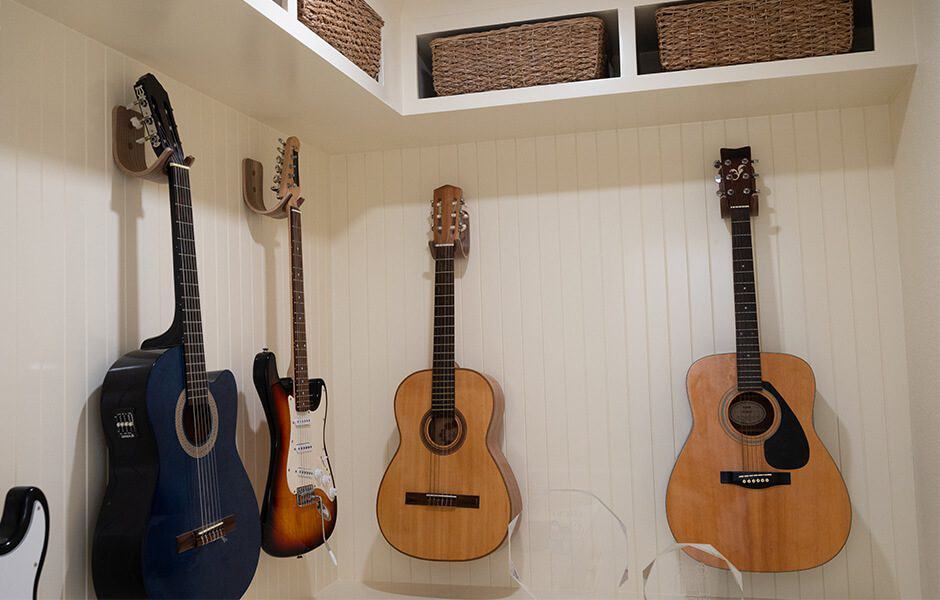 Wall-mounted guitar collection with woven storage baskets above