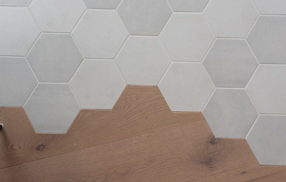 Hexagon tile transition to wood flooring with a seamless geometric design