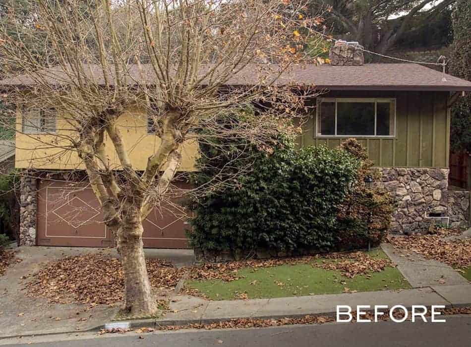 Before image of a two-story house with a brown roof and siding, with many leaves scattered on the ground