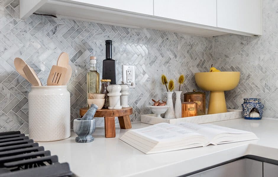 Modern kitchen counter with utensils, ingredients, and an open cookbook