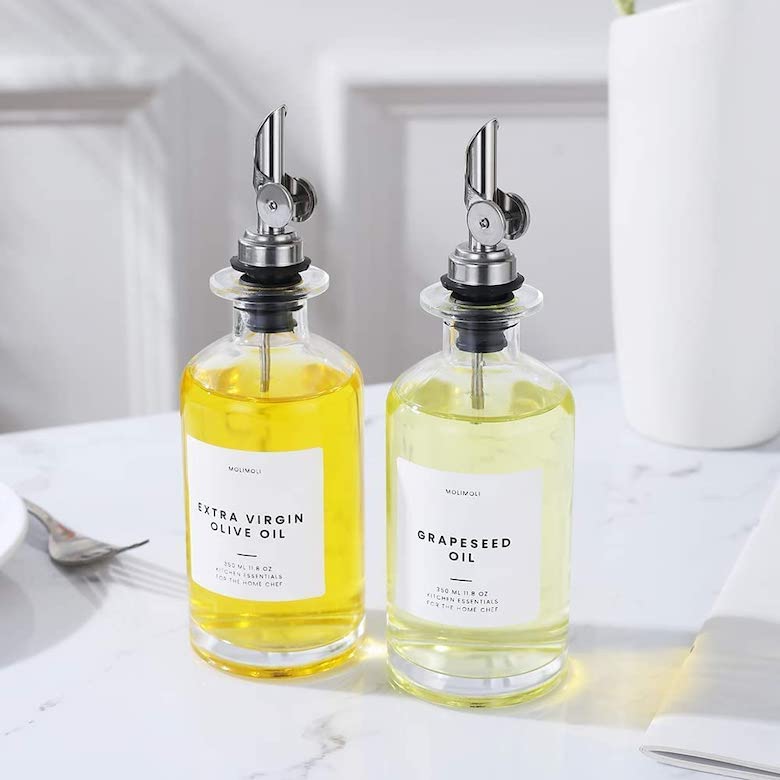 Glass oil dispensers with olive oil and grapeseed oil on a countertop