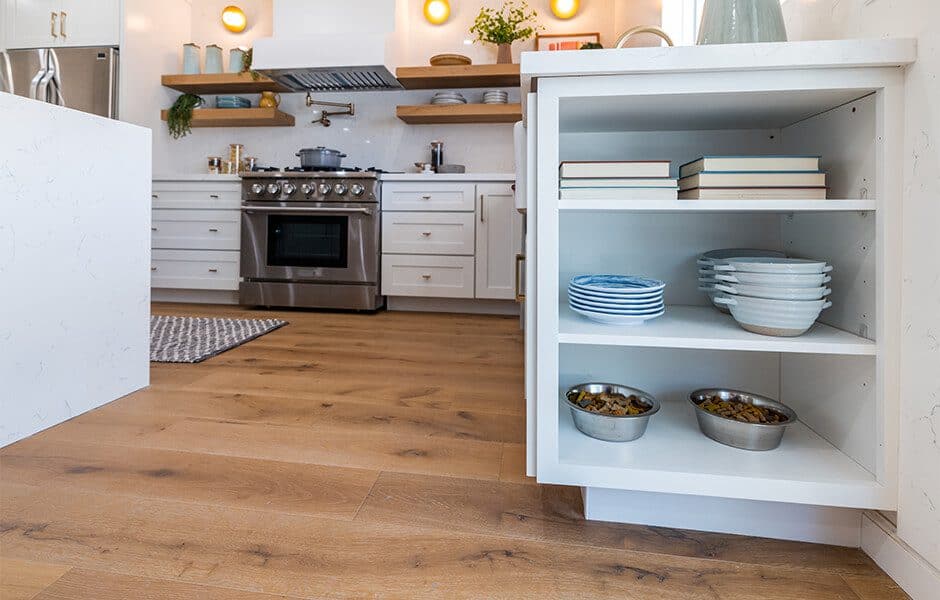 Modern kitchen with white cabinets, quartz countertop, stainless steel range, and white cabinet with open shelves