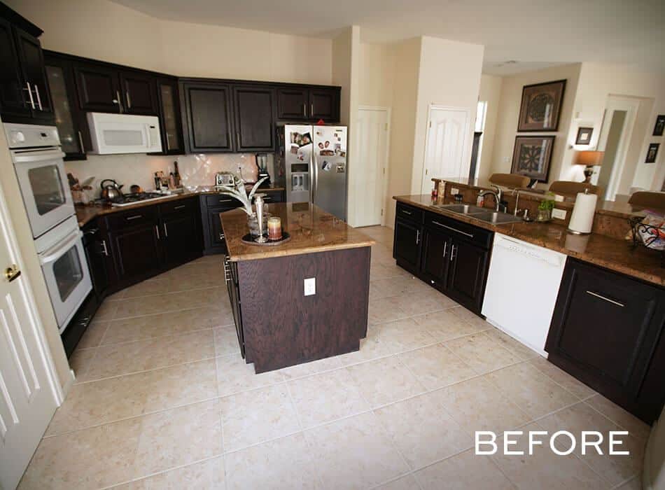 A dated kitchen with dark cabinets, granite countertops, and a central island (before renovation)