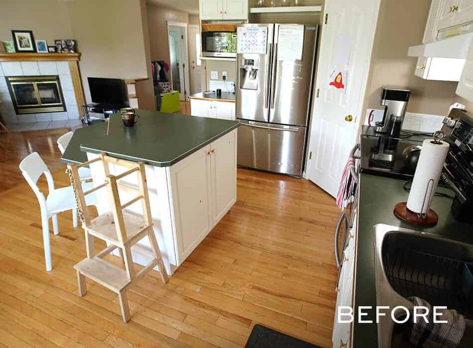 Traditional kitchen with a green countertop island, wooden floors, and white cabinetry