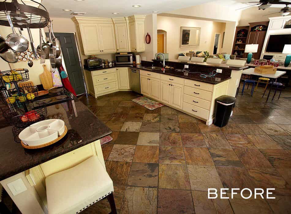 Dated kitchen with white cabinets, dark countertops, and slate tile flooring (before renovation)
