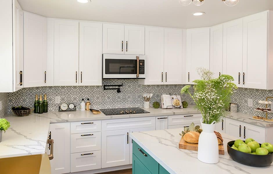 Bright kitchen with white cabinets, patterned backsplash, and marble countertops