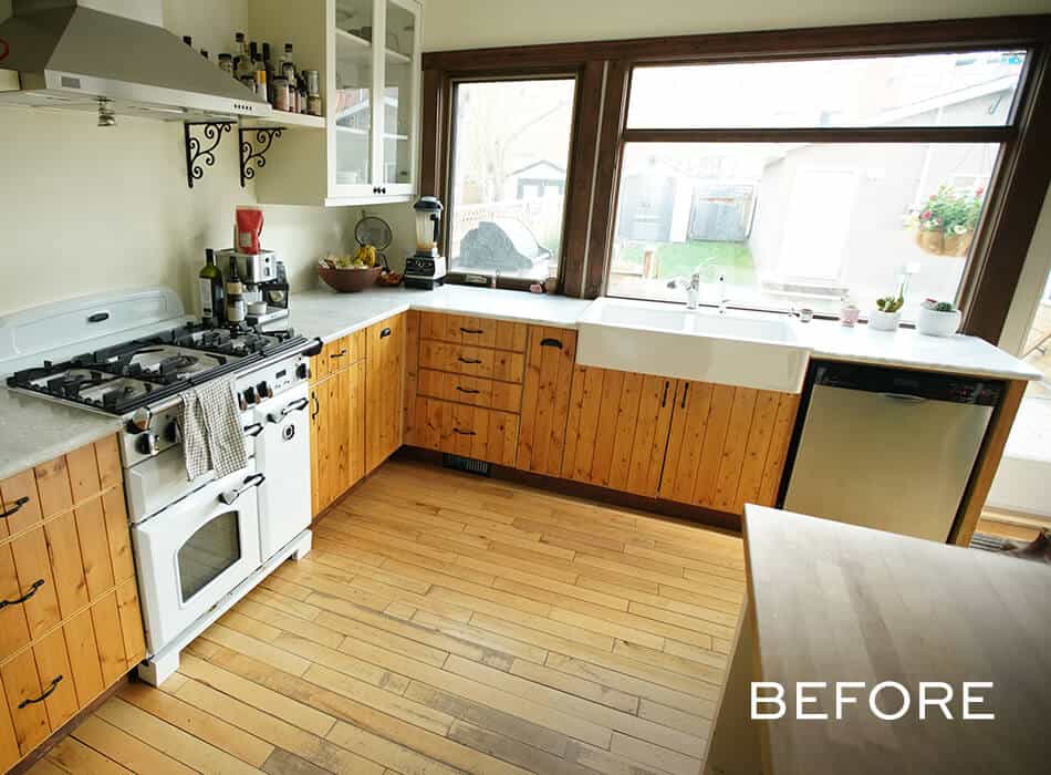 Kitchen with wood cabinets, white farmhouse sink, vintage stove, and large windows