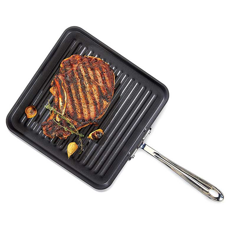 Grilled steak with herbs and garlic on a black square grill pan