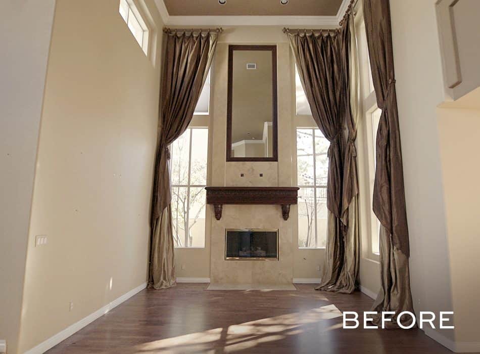 Tall living room with fireplace mirror and dark floor length curtains