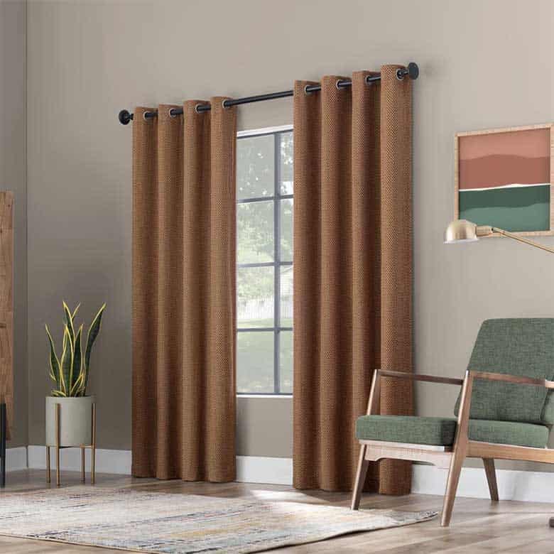 Mid-century modern living space with textured brown curtains, a green armchair, and a minimalist floor lamp