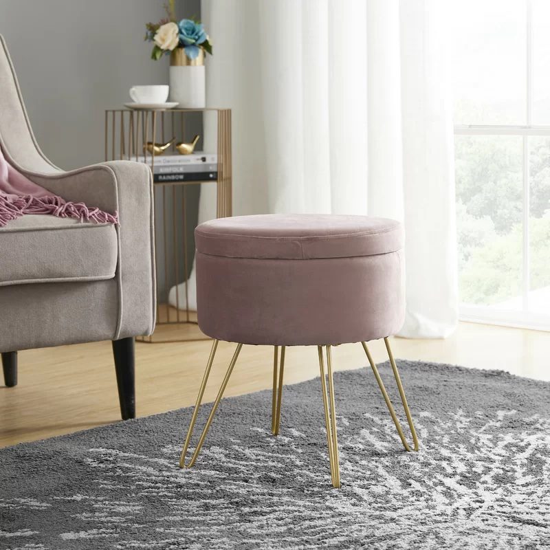 Elegant living space with a blush pink velvet ottoman, a cozy armchair, and a modern side table