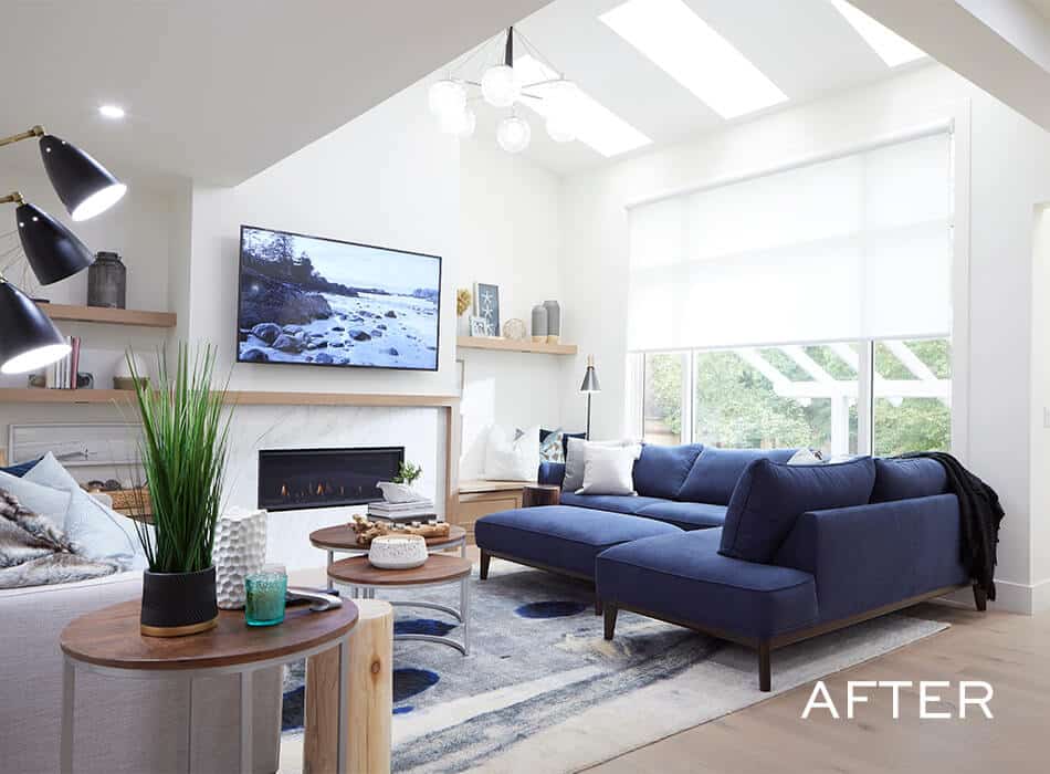 Bright living room with navy sofa, skylights, TV, and modern decor