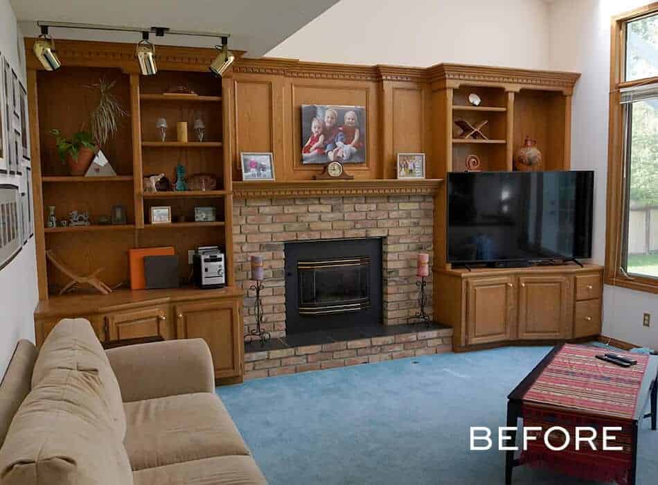 Traditional living room with wooden built-ins, brick fireplace, and blue carpet