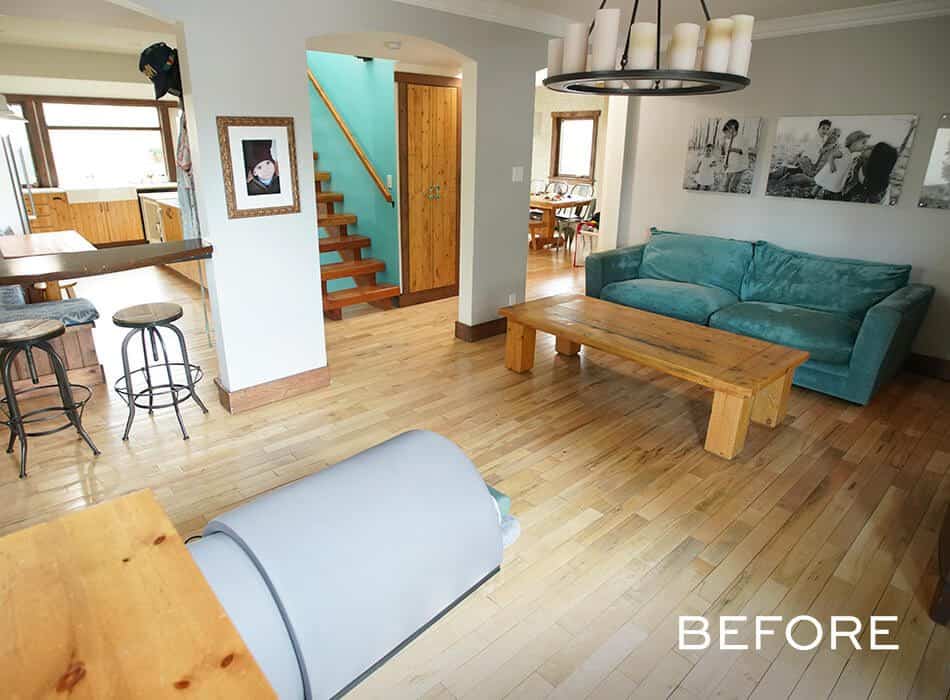 Living room with a teal sofa, wooden coffee table, and bar stools