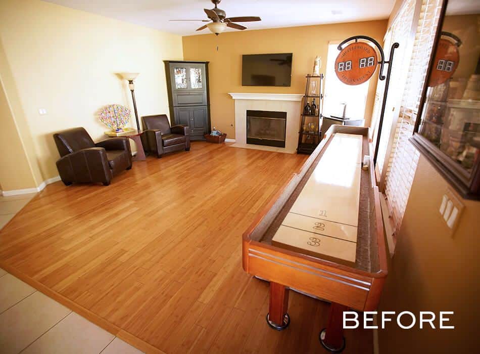 Living room with hardwood floors, chairs, a fireplace, and a shuffleboard table