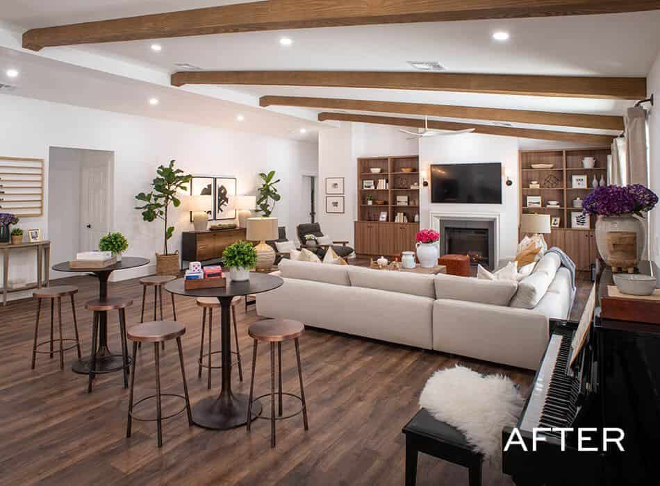 Spacious living area with wood beam ceilings, a large sectional, built-in shelves, and a modern fireplace