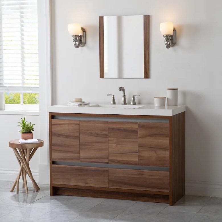 Wood bathroom vanity with white countertop, wall mirror, and modern sconces on each side
