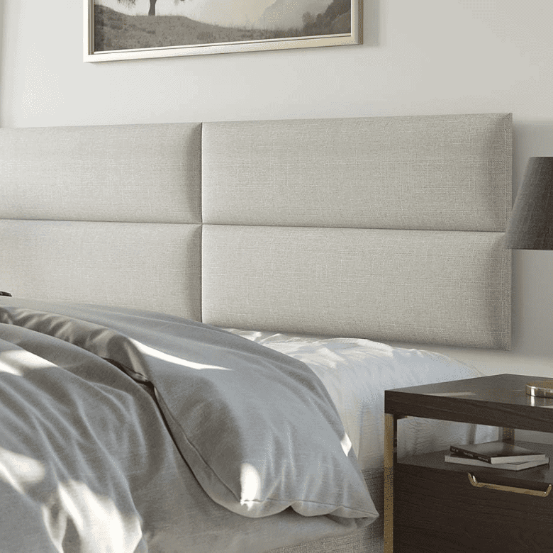 Bedroom with a light gray upholstered headboard, gray bedding, and a dark wooden nightstand