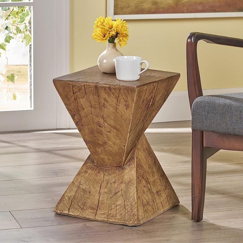 Wooden side table with a geometric design, holding a vase of yellow flowers and a white mug