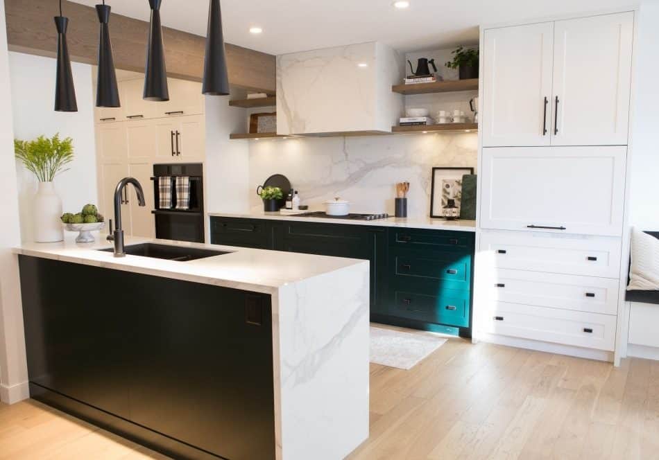 Renovated kitchen featuring sleek black and white cabinetry, a marble countertop, and minimalistic pendant lighting