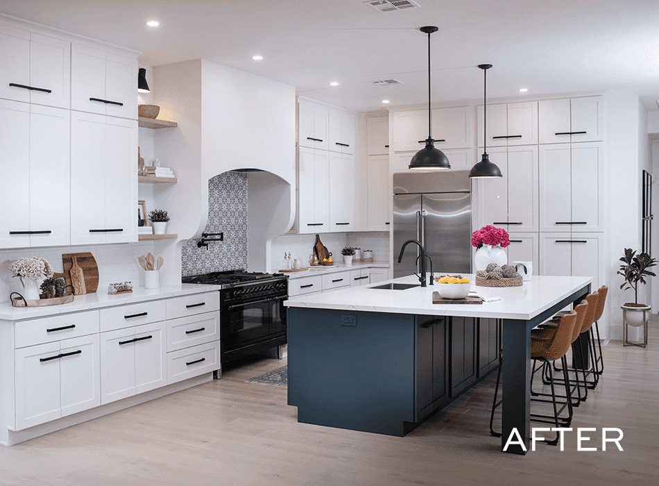 Modern kitchen with white cabinets, a navy island, pendant lighting, and stainless steel appliances