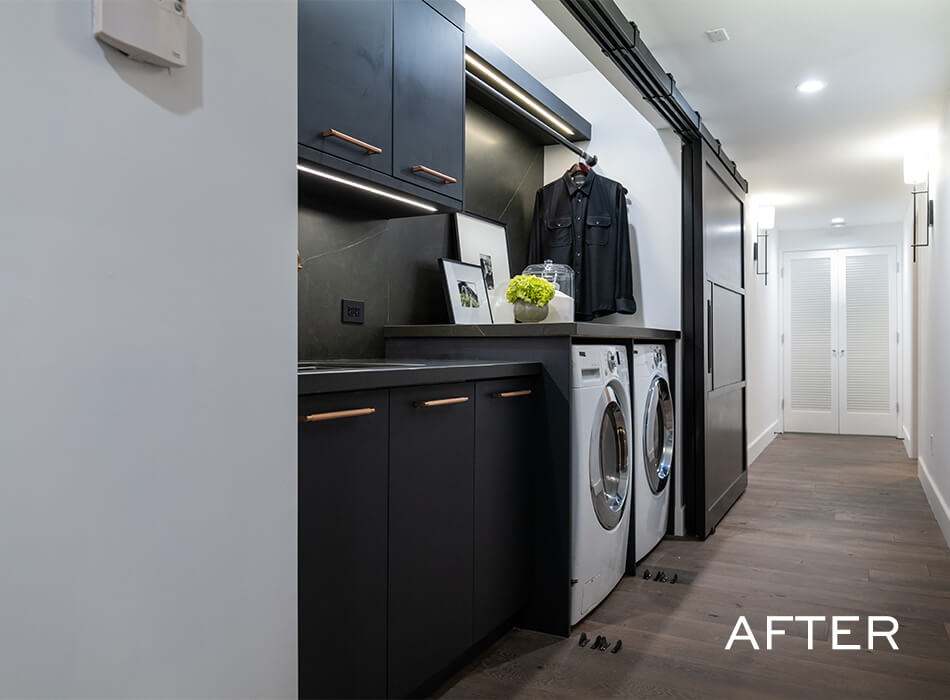 Modern laundry room with black cabinets, washer and dryer, and sliding storage door