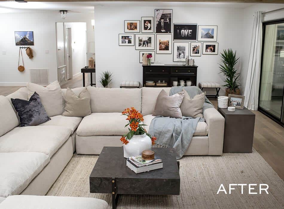 Living room with white sectional sofa, coffee table, photo gallery wall, fireplace, doorway, and window