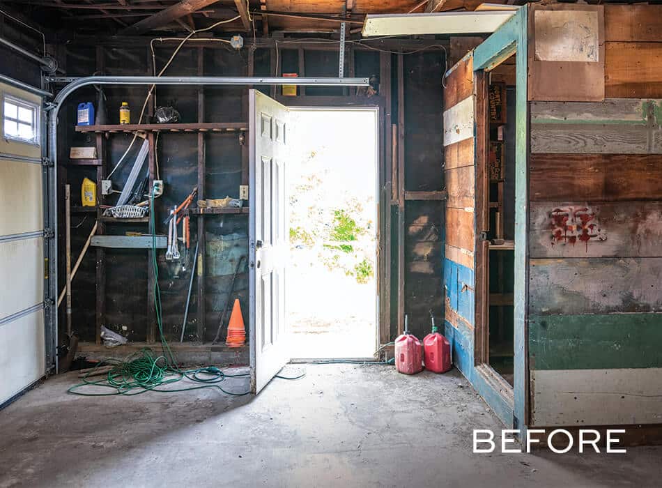 Rustic garage with exposed wood walls, open door, and scattered tools