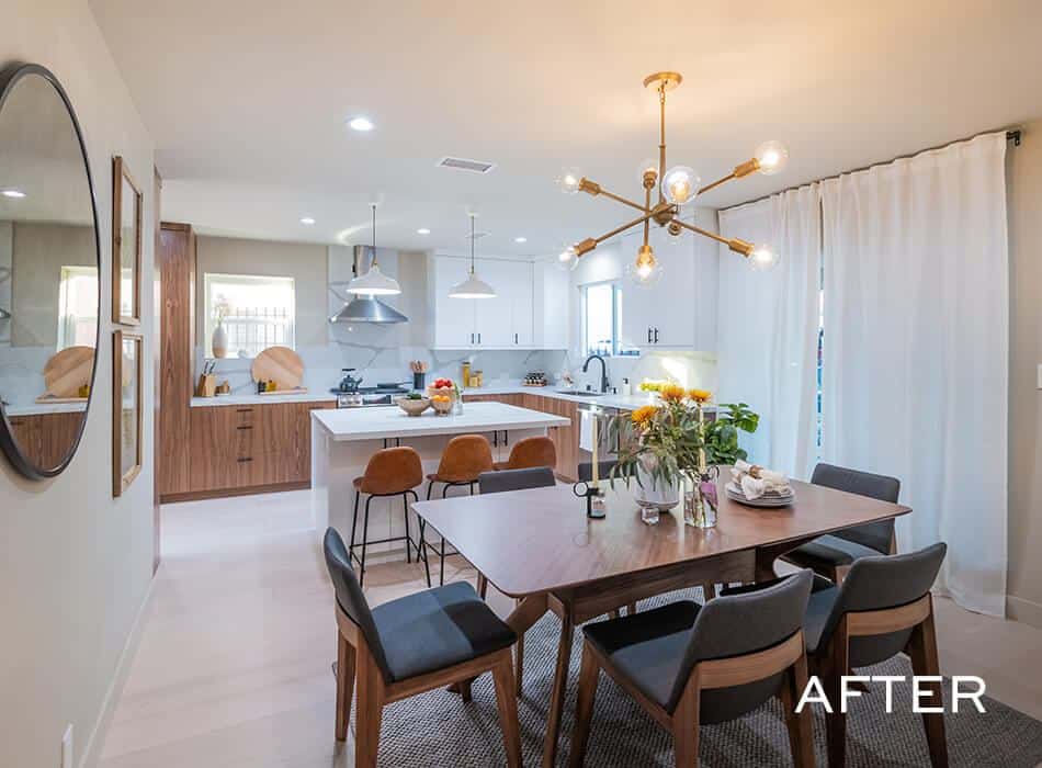 A spacious kitchen and dining room with white cabinets, a marble countertop, and a large dining table