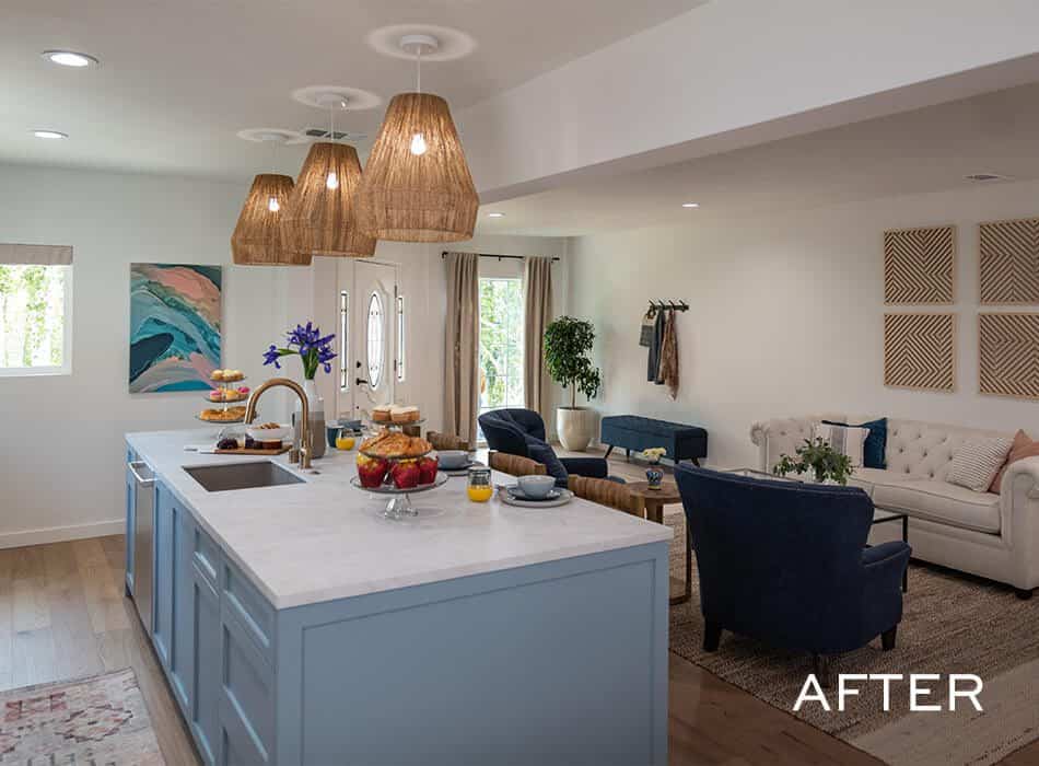 A kitchen with blue cabinets, light fixtures, and a cozy living space