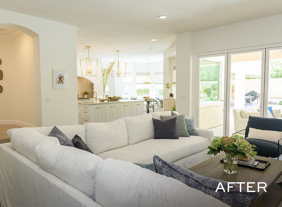 Bright living room with white sofa, navy chair, and natural light