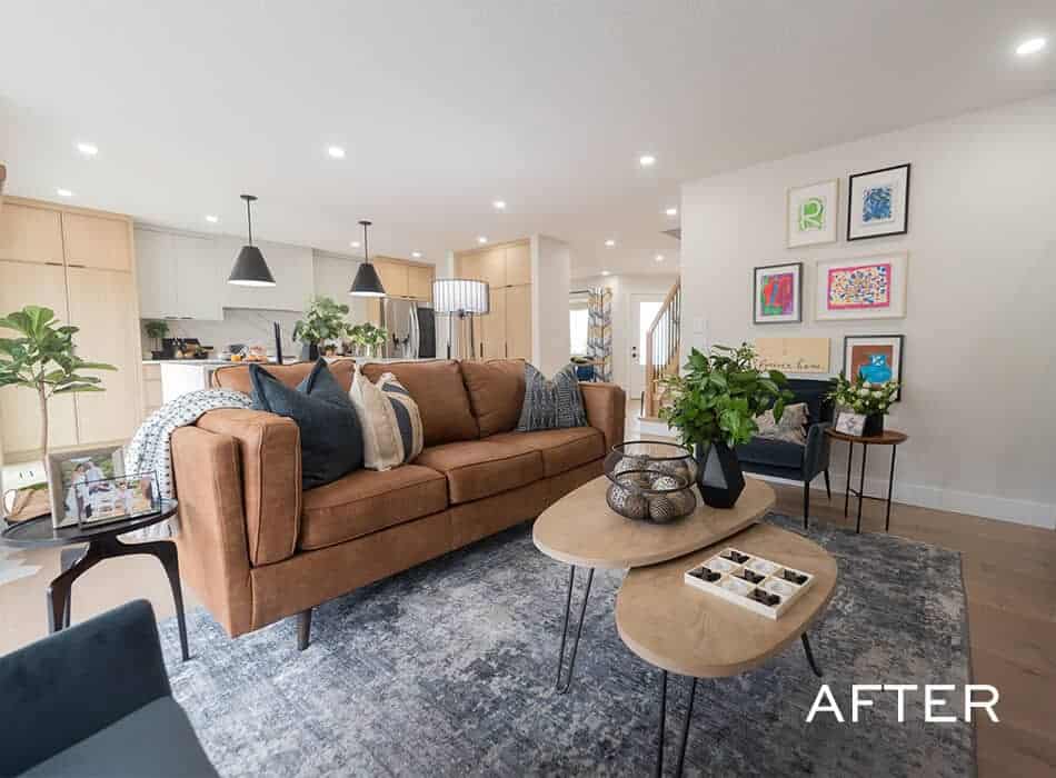 Modern living room with a brown sofa, decorative pillows, nested coffee tables, indoor plants, and colorful artwork on the wall