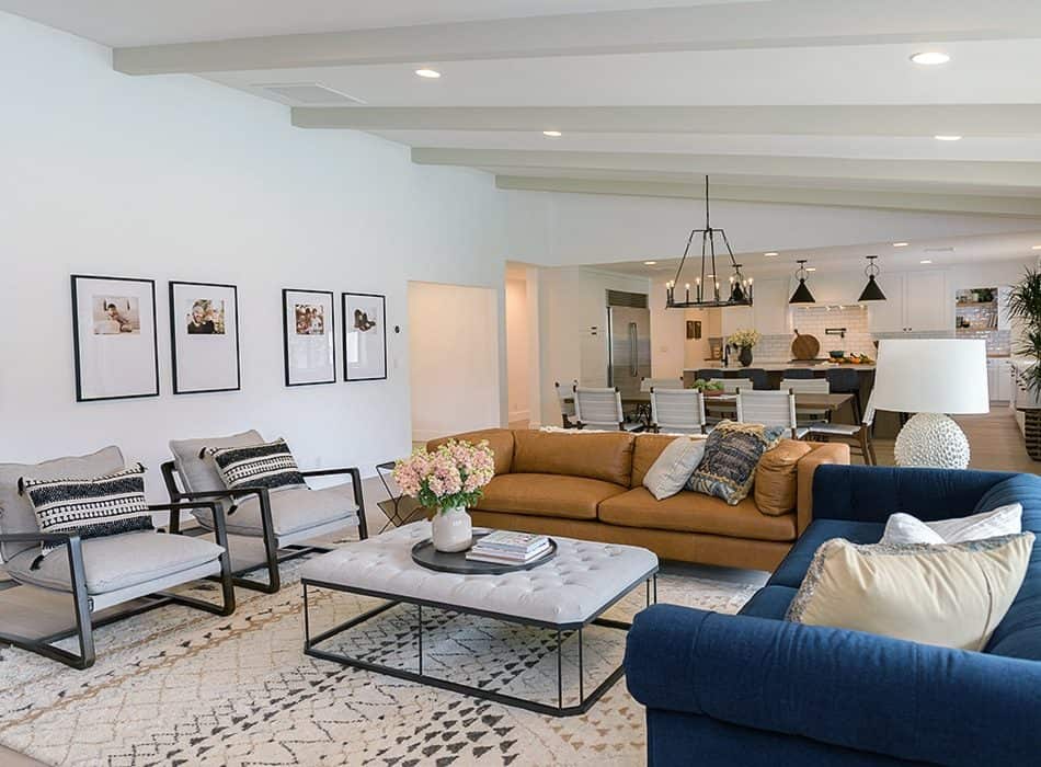 Open-concept living room with colorful seating, framed art, and a flow to the dining and kitchen areas