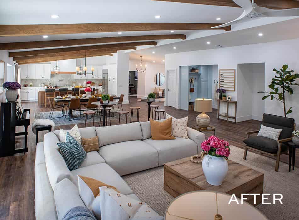 Open-concept living space with vaulted wood beam ceiling, modern kitchen, and cozy seating area