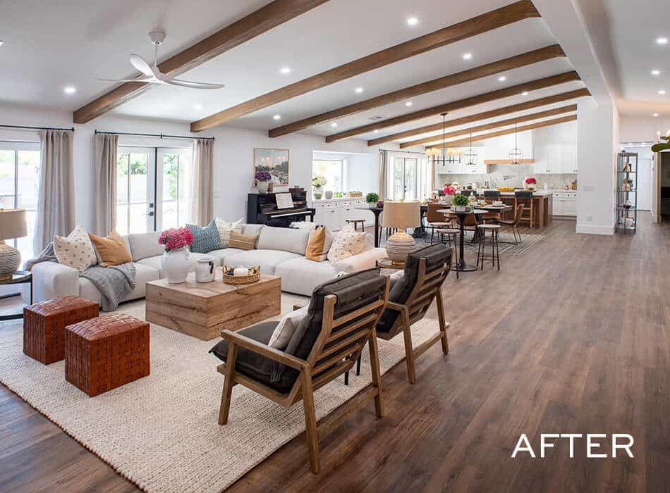 Spacious open-concept living area with wood beams, modern furnishings, and a seamless flow into the kitchen