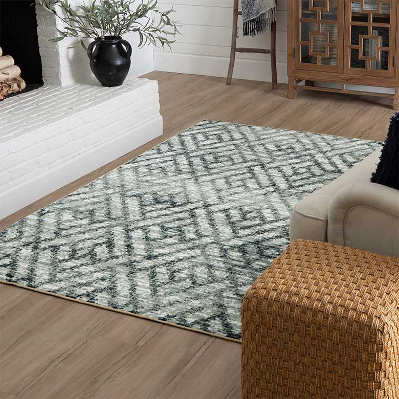 Living room with a gray geometric rug, white brick fireplace, and cozy neutral decor