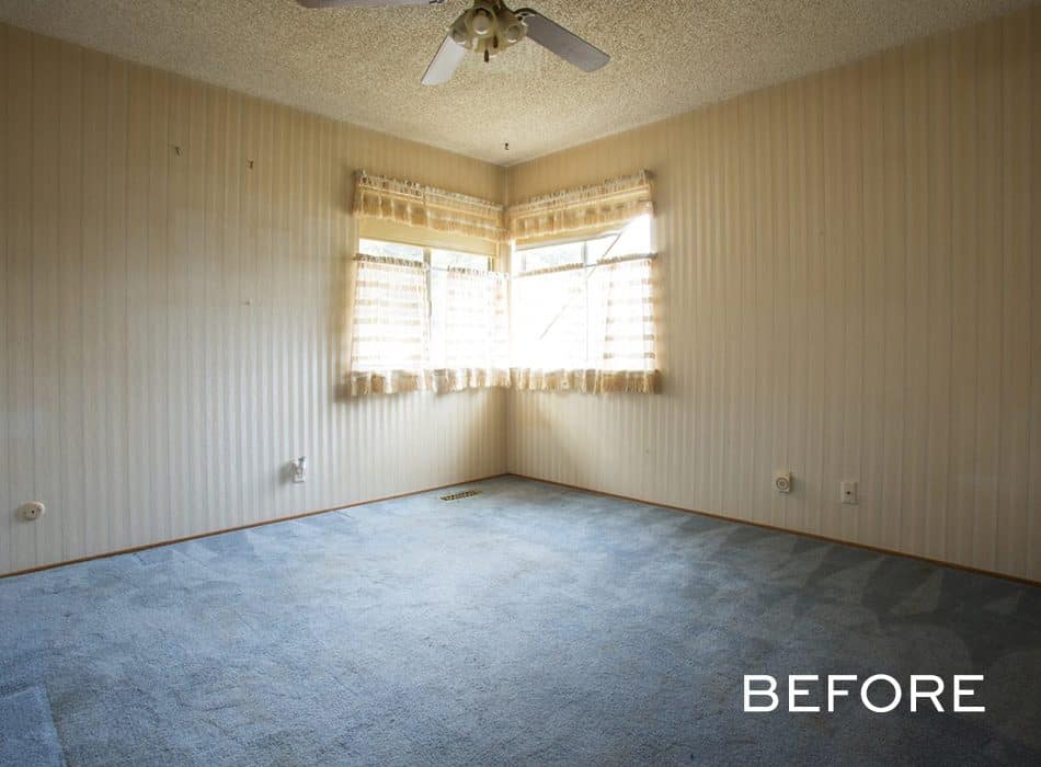 Empty room with beige walls, blue carpet, and corner windows