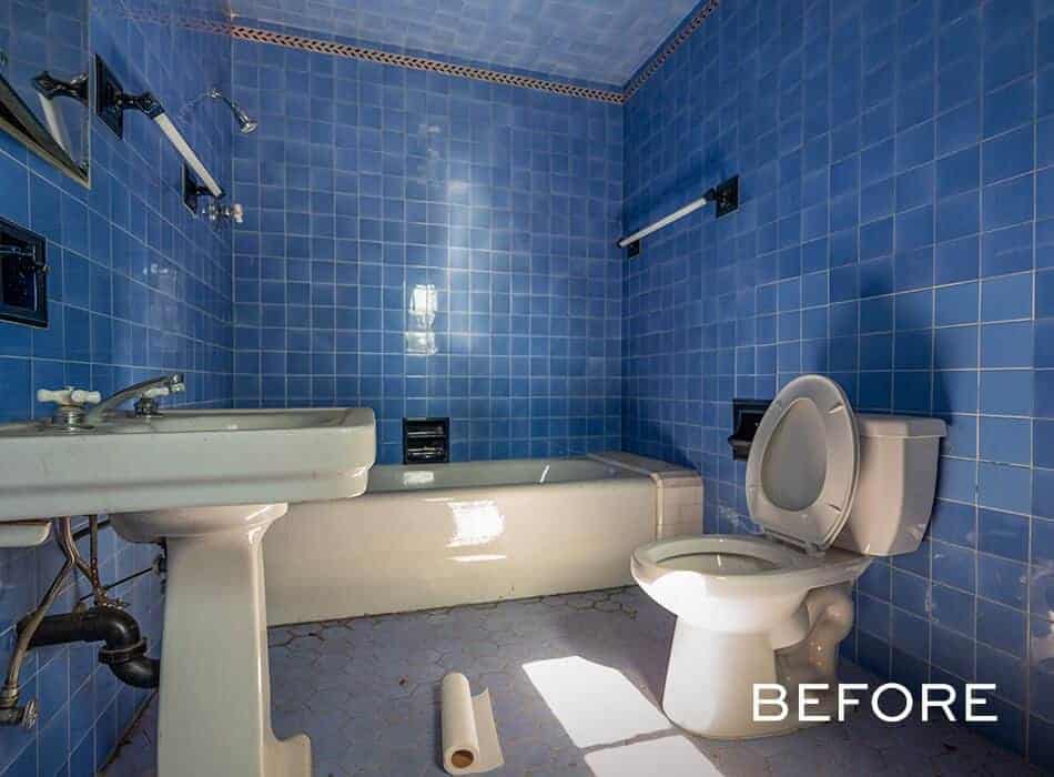 Outdated bathroom with blue tile walls, pedestal sink, bathtub, toilet
