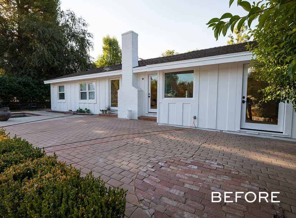 Single-story white house with brick patio and chimney
