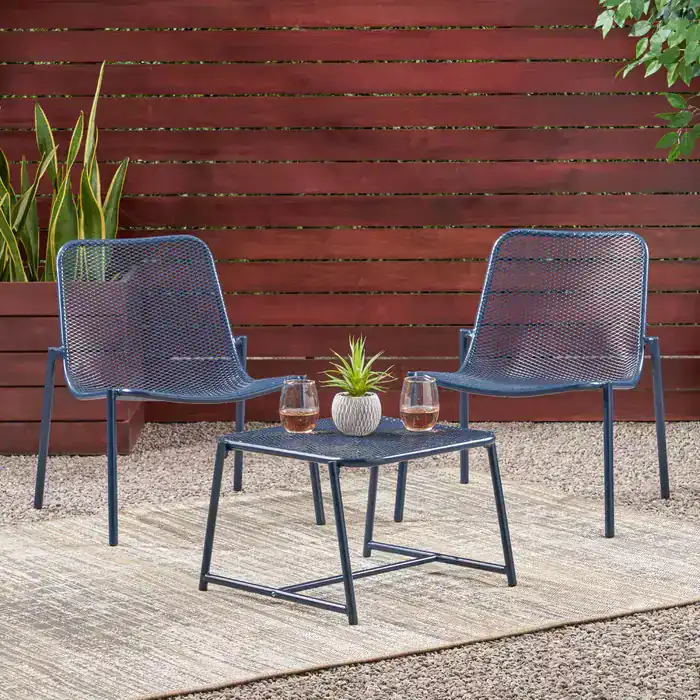 Modern outdoor seating area with two metal mesh chairs and a small table